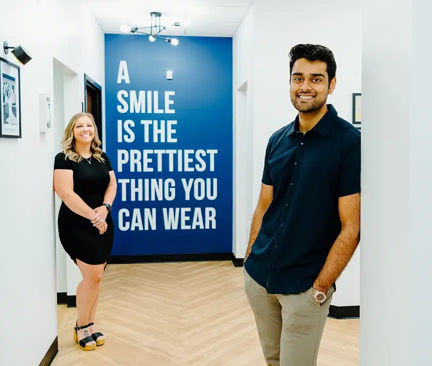 Dr. Dushyant Patel standing next to a blue "Wellness Hour" banner in a medical clinic lobby.