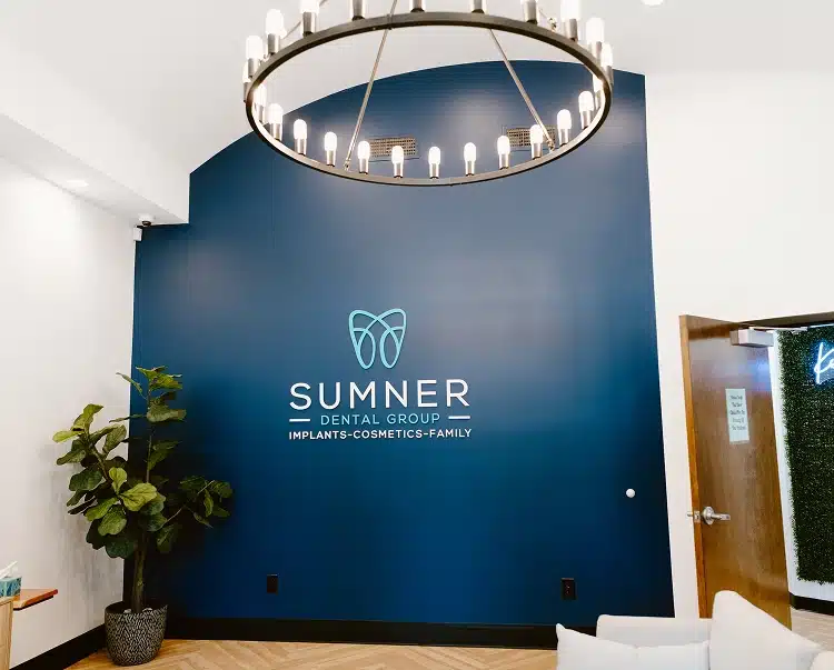 he modern lobby of Sumner Dental Group showing a large ring chandelier and a blue accent wall.